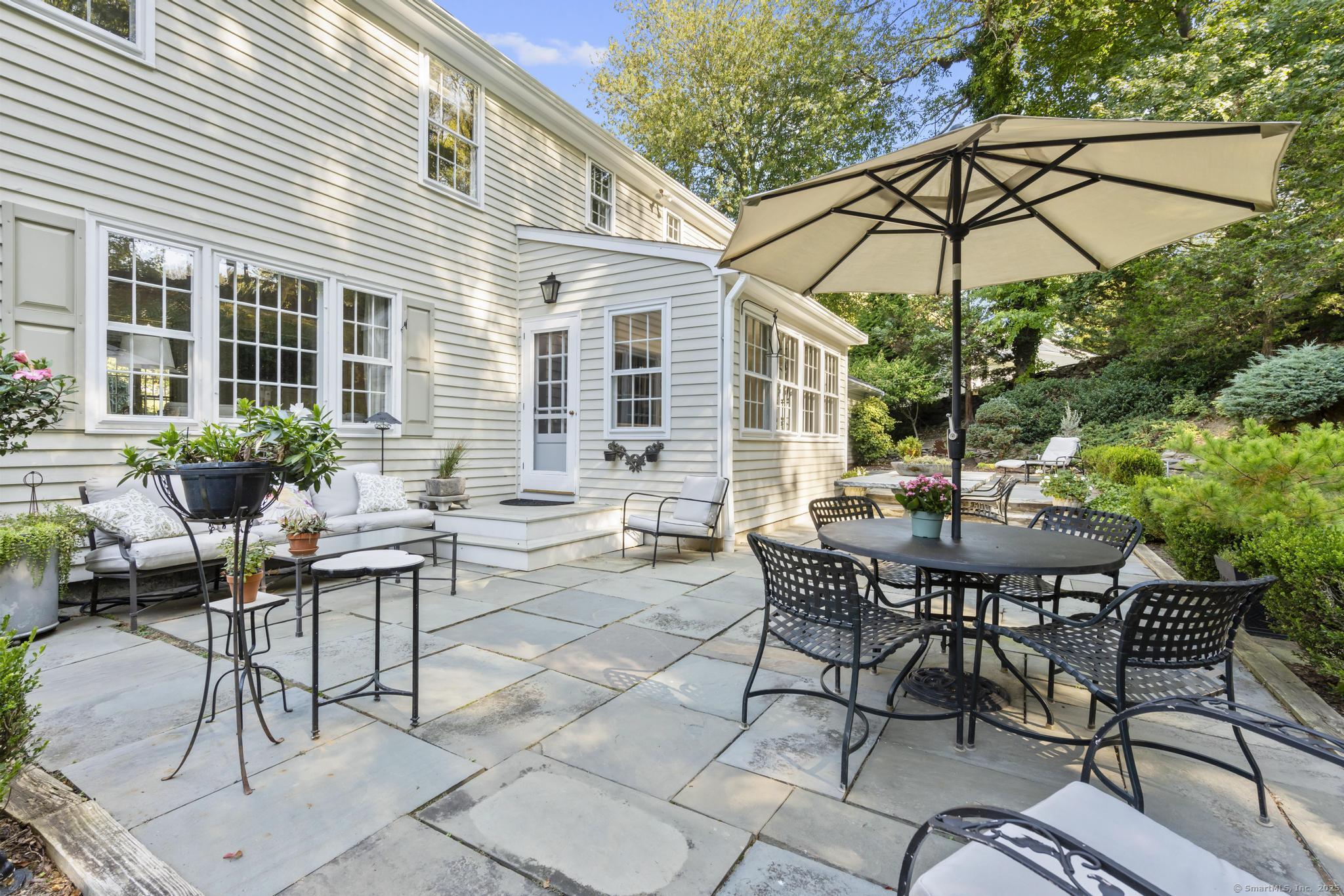 1165 Stillson Road Fairfield, CT 06824 - Photo 36 of 40 a view of a patio with a table and chairs under an umbrella