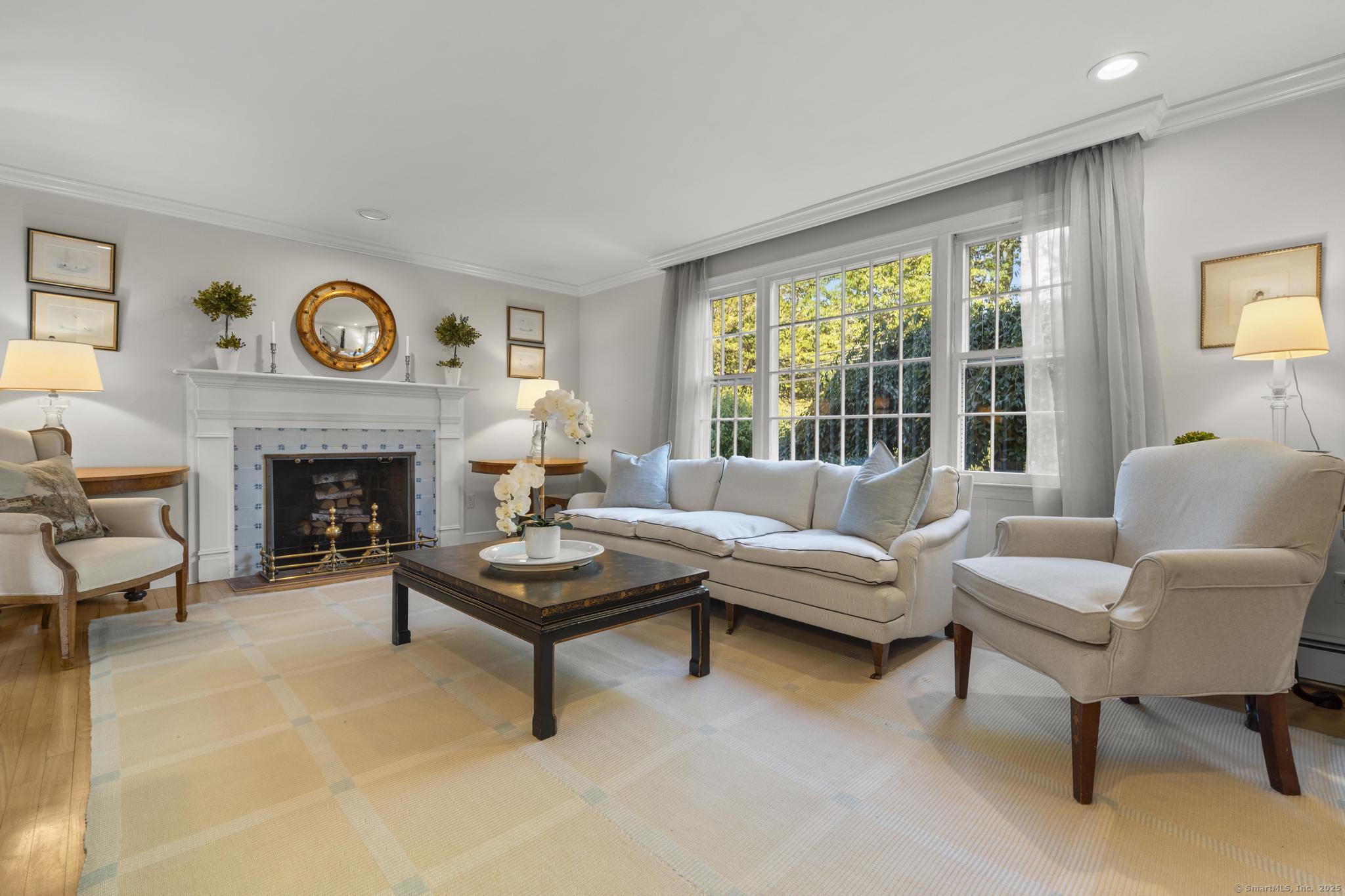 1165 Stillson Road Fairfield, CT 06824 - Photo 8 of 40 a living room with furniture a fireplace and a large window