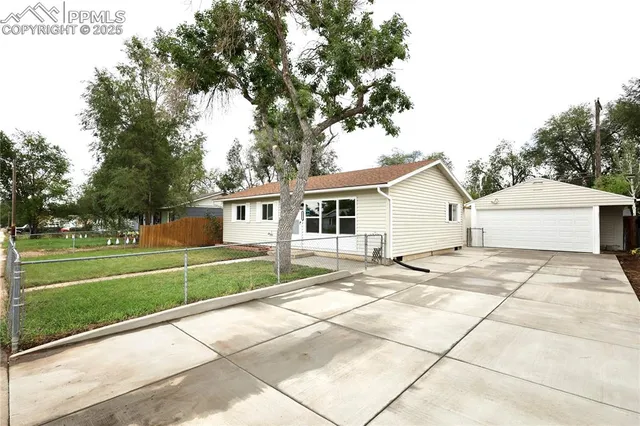 a view of a house with a big yard and large trees
