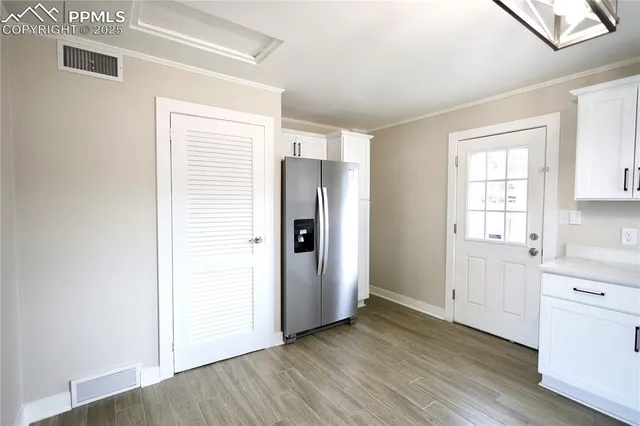 a view of a kitchen with wooden floor and electronic appliances
