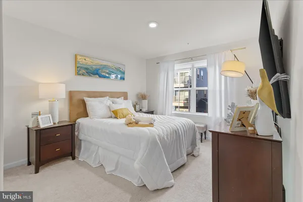 a bedroom with a bed and a flat tv screen on the dresser