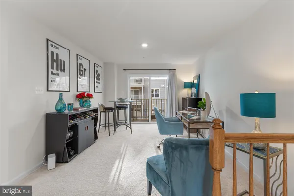 a living room with furniture a flat screen tv and kitchen view