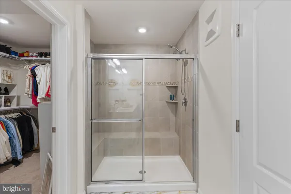 a view of walk in closet with clothes and shoes