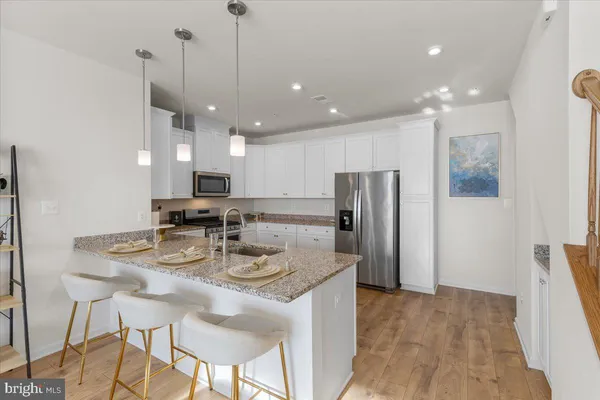 a kitchen with refrigerator and chairs