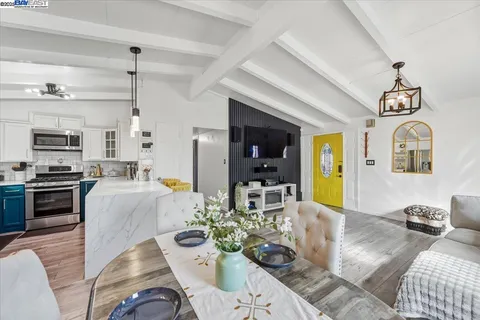 a living room with stainless steel appliances kitchen island granite countertop furniture and a view of kitchen