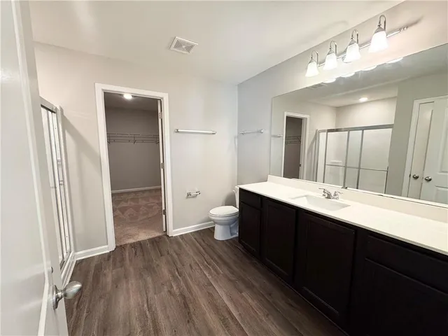 a spacious bathroom with a double vanity sink toilet and shower