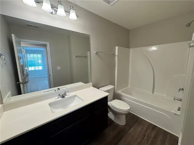 a bathroom with a double vanity sink toilet and shower
