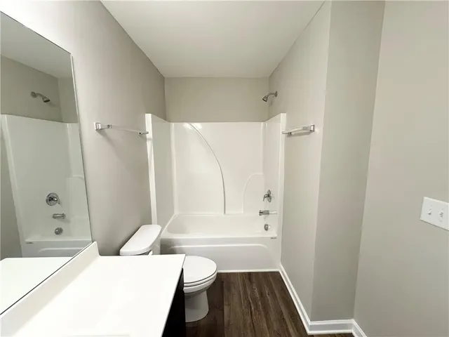 a bathroom with a bathtub shower sink vanity and toilet