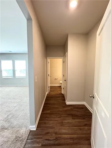 a view of a hallway with wooden floor and closet