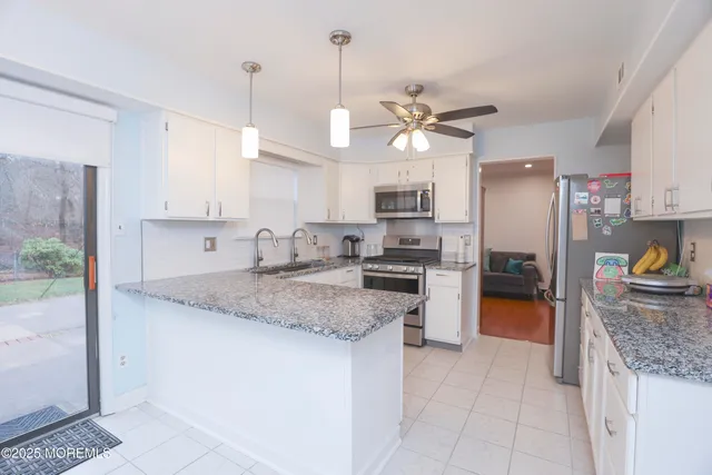 a kitchen with kitchen island granite countertop stainless steel appliances a stove refrigerator and microwave