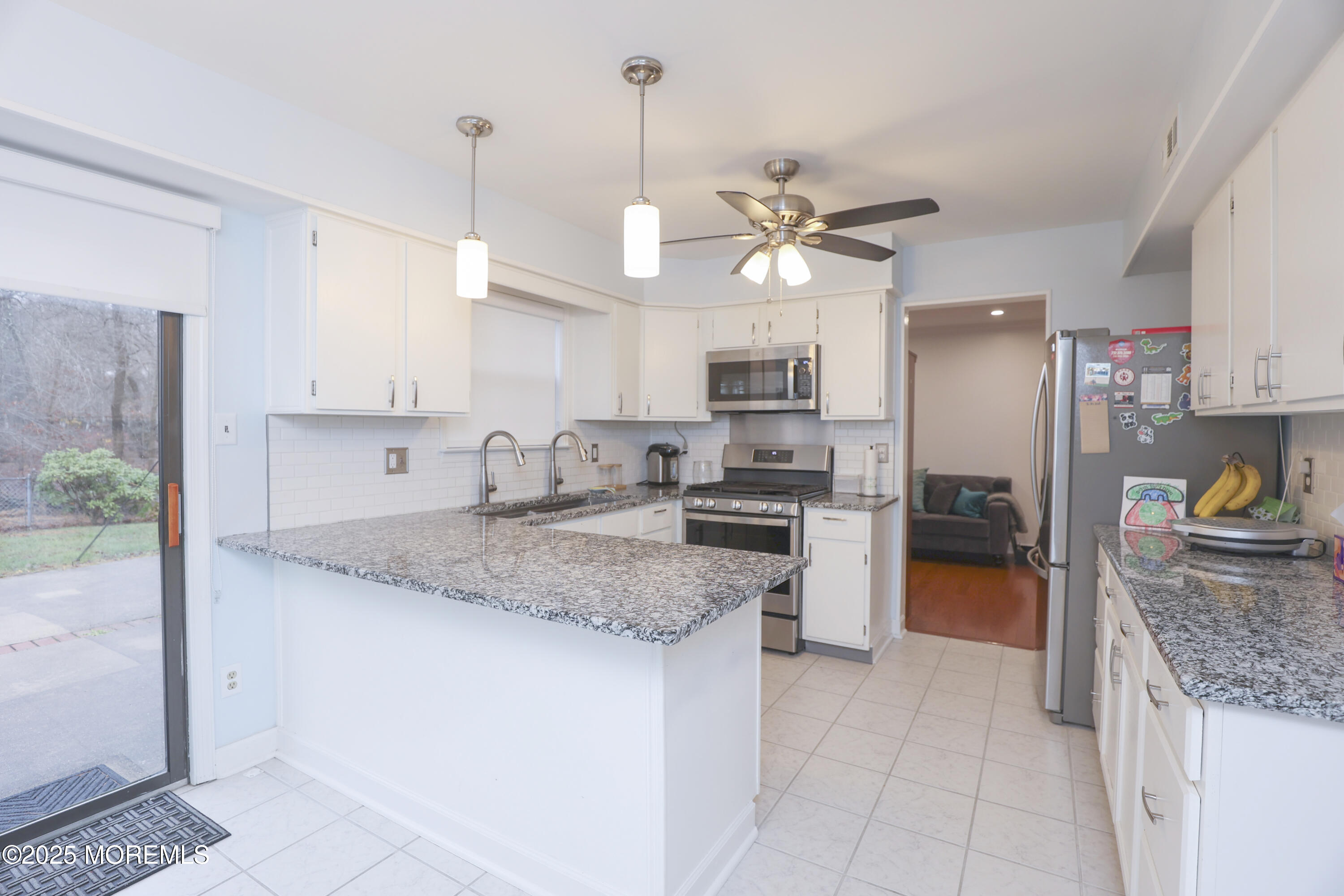 302 Princeton Drive Howell, NJ 07731 - Photo 12 of 30 a kitchen with a center island and stainless steel appliances