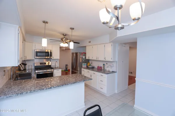 a kitchen with kitchen island granite countertop stainless steel appliances a stove refrigerator and microwave