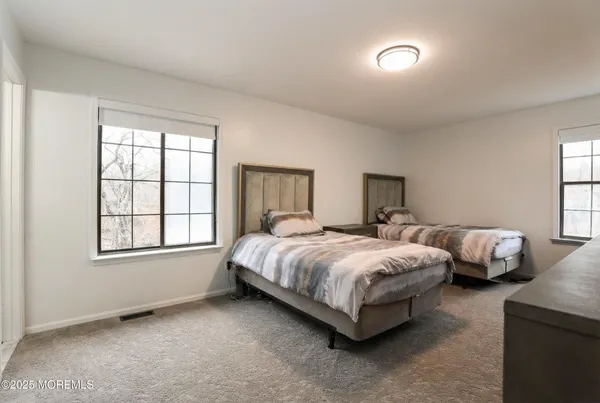 a spacious bedroom with two bed and a window
