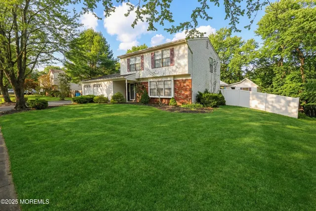 a view of a house with a big yard and large trees