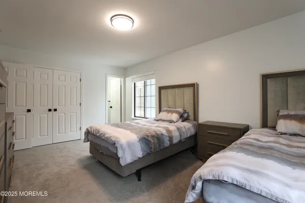 a bedroom with two beds and a closet