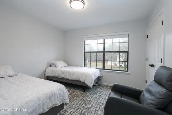 a bedroom with bed couch and window