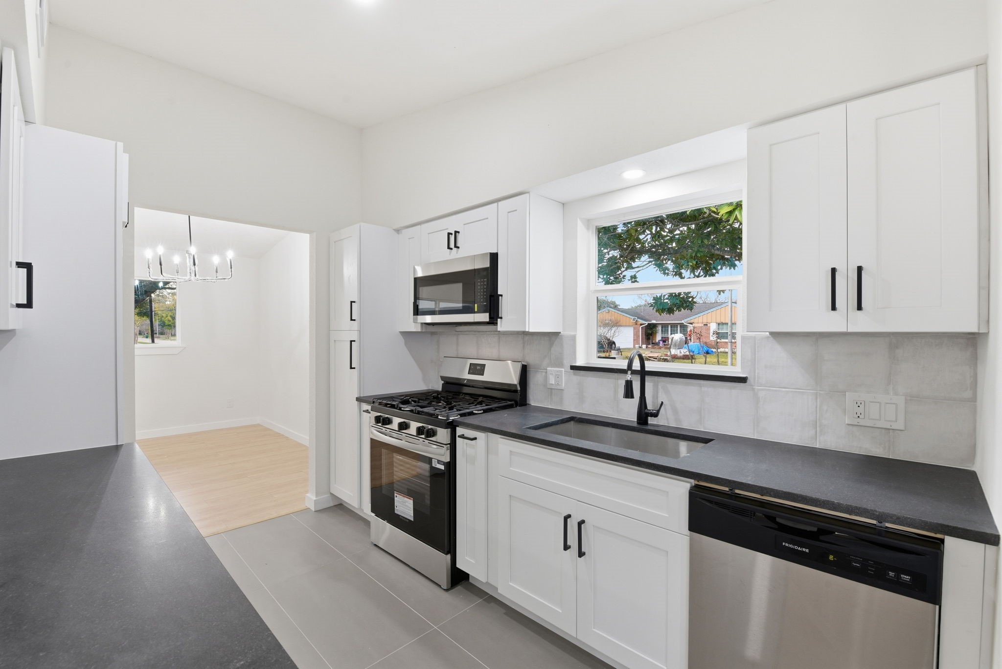 12319 Renwick Houston, TX 77035 - Photo 19 of 50 a kitchen with granite countertop a stove a sink dishwasher and a refrigerator with wooden floor
