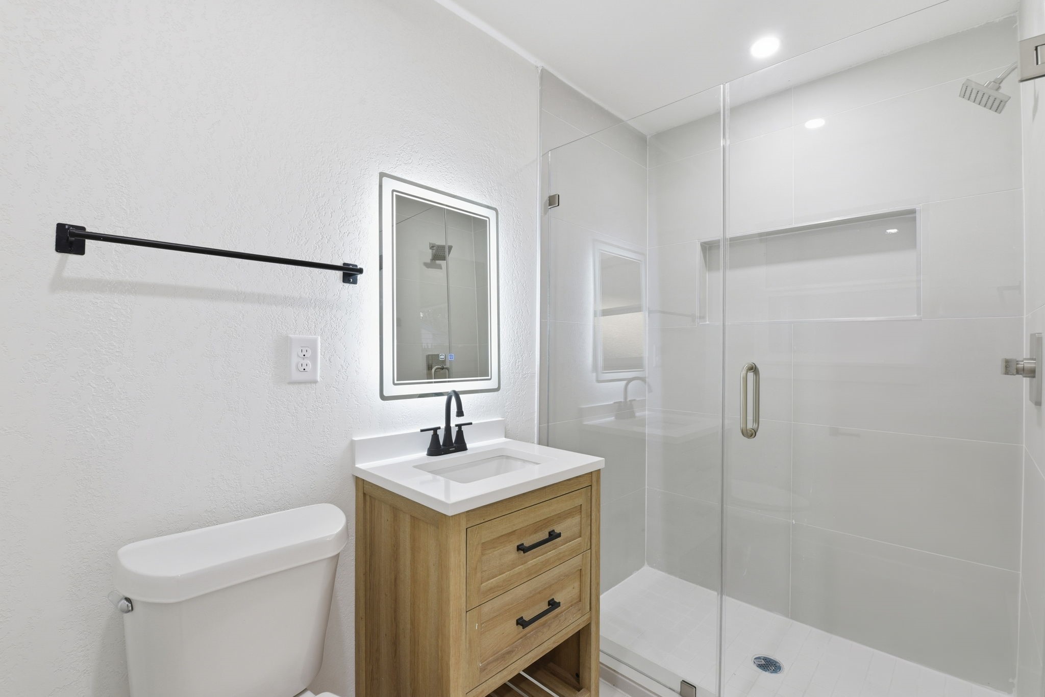 12319 Renwick Houston, TX 77035 - Photo 33 of 50 a bathroom with a toilet a sink a mirror a shower and vanity