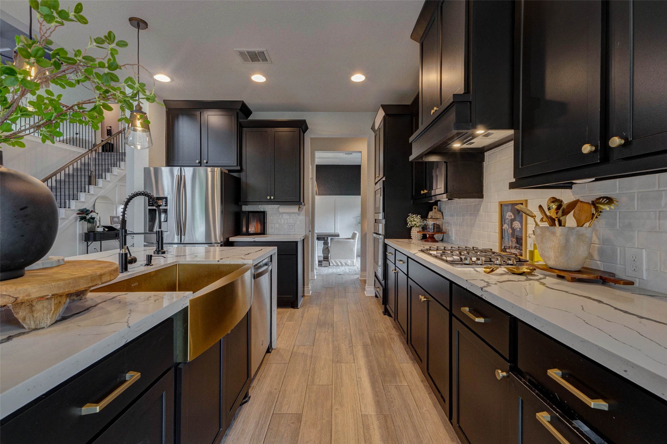 4303 Tupelo Leaf Court Manvel, TX 77578 - Photo 21 of 50 a large kitchen with stainless steel appliances kitchen island granite countertop a sink counter space and cabinets
