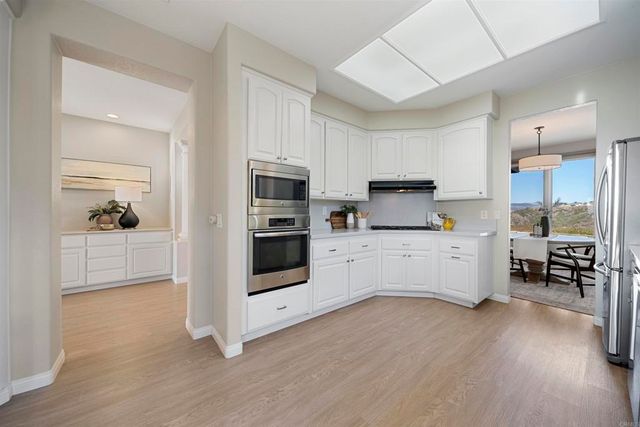 a kitchen with white cabinets and stainless steel appliances