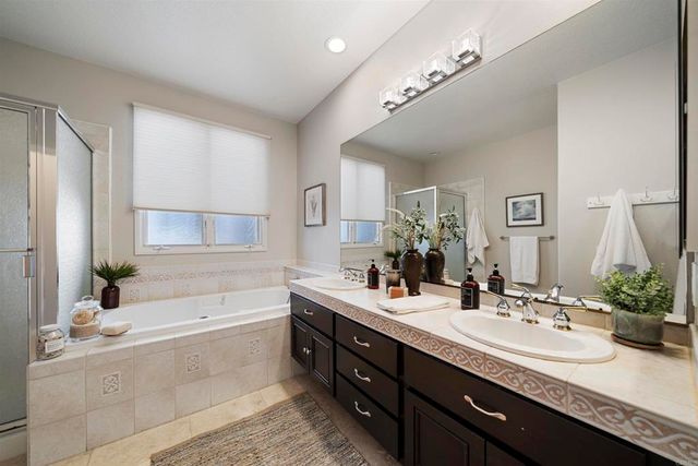 a bathroom with a granite countertop bathtub double sink and mirror