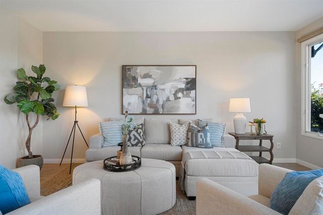 a living room with furniture a lamp and a potted plant