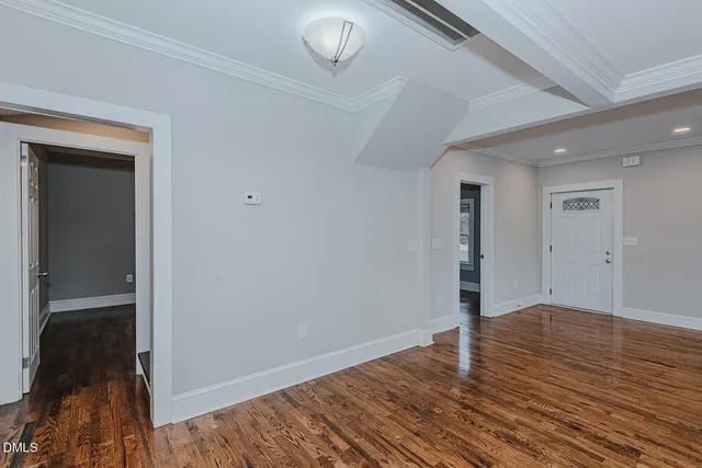 a view of an empty room with wooden floor