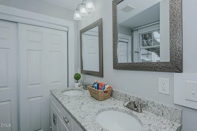a bathroom with a granite countertop sink and a mirror