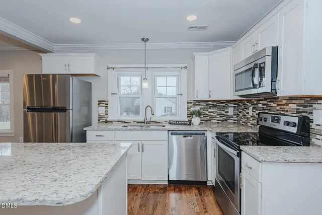 a kitchen with stainless steel appliances granite countertop a stove refrigerator sink and cabinets
