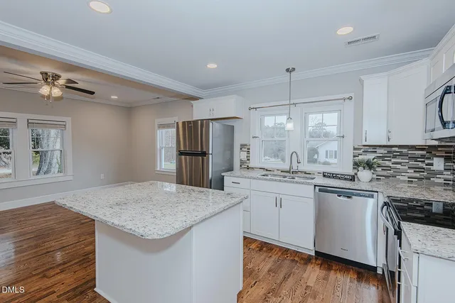 a kitchen with stainless steel appliances granite countertop hardwood a kitchen island sink stove and refrigerator
