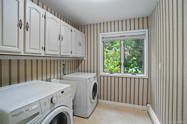 a view of washer and dryer with bathtub in a room