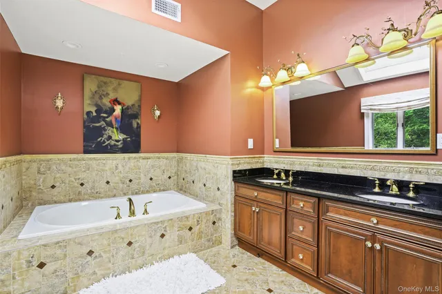 a bathroom with a tub a sink and a mirror