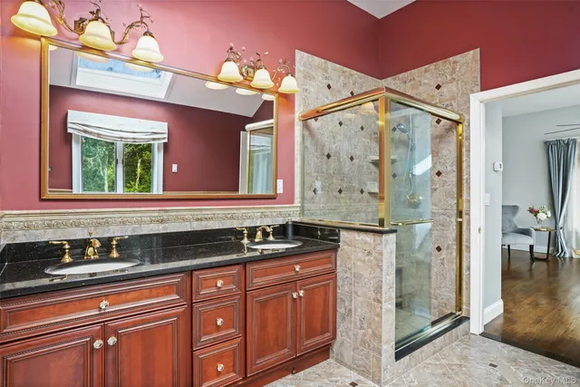 a bathroom with a granite countertop sink mirror and a shower