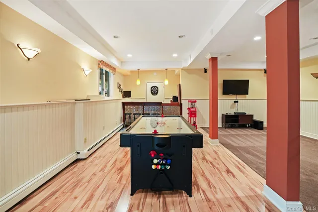 a living room with a bed and wooden floor