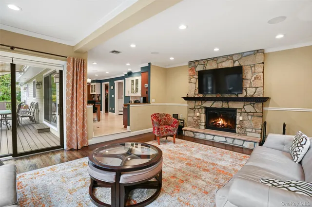 a living room with furniture a flat screen tv and a fireplace