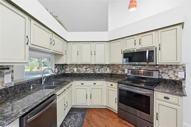 a kitchen with stainless steel appliances granite countertop a sink and a stove