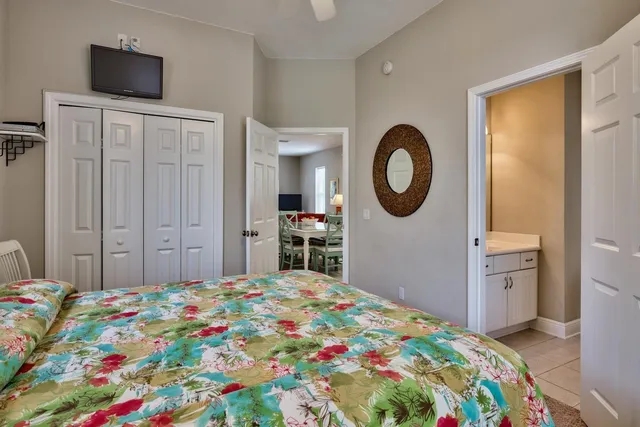 a bedroom with a bed and a flat tv screen on dresser