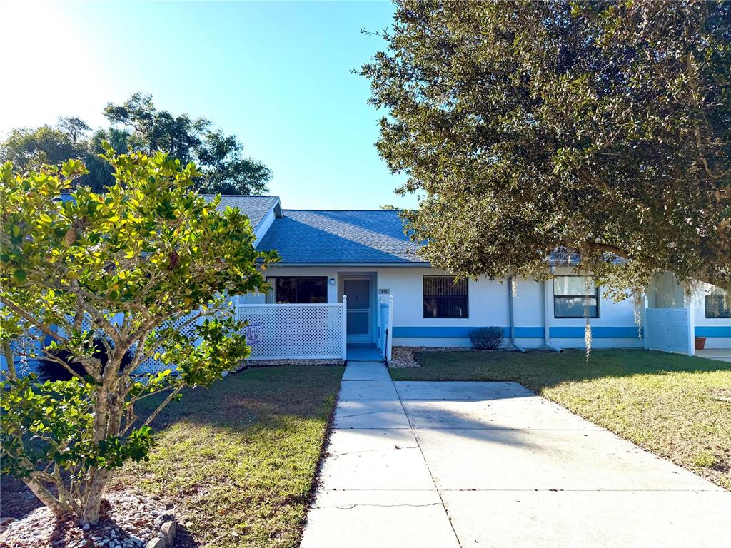 a front view of a house with a yard and a garden