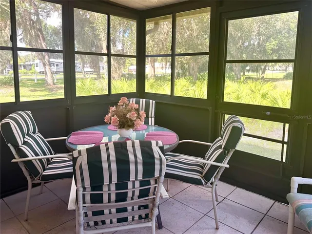 a bedroom with a bed a desk and chair with windows