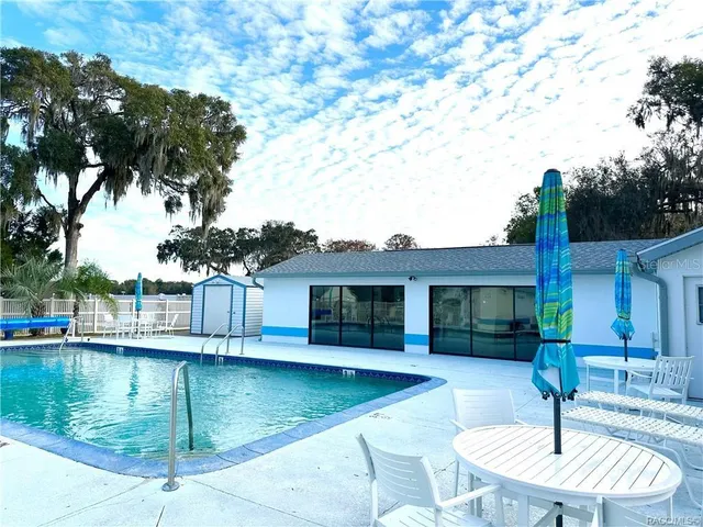 a view of a house with swimming pool and a bench