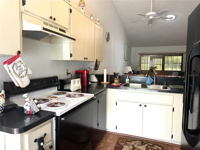 a kitchen with a sink dishwasher and a stove with wooden floor