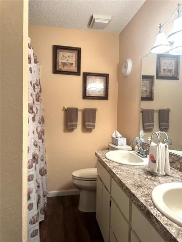 a bathroom with a granite countertop sink mirror vanity and toilet