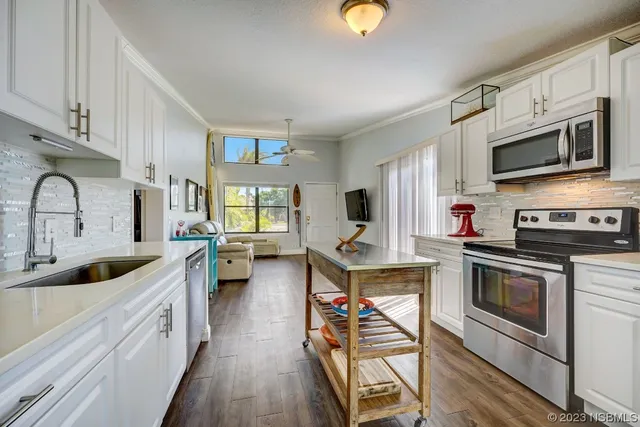 a kitchen with stainless steel appliances a stove sink microwave and cabinets