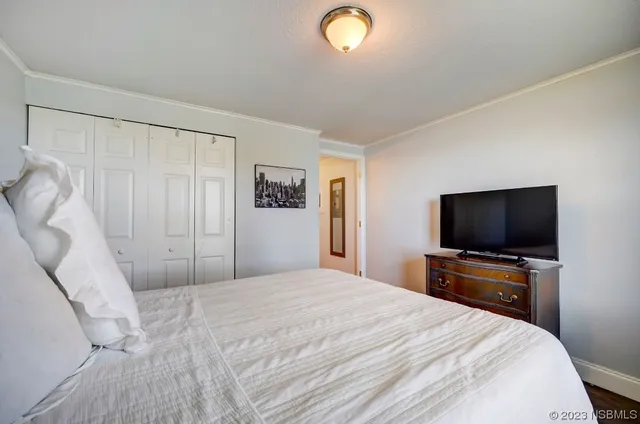 a bedroom with a bed and a flat screen tv