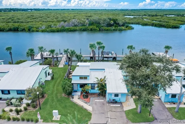 an aerial view of a house with garden space and a lake view