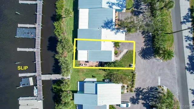 an aerial view of a house with a garden and lake view