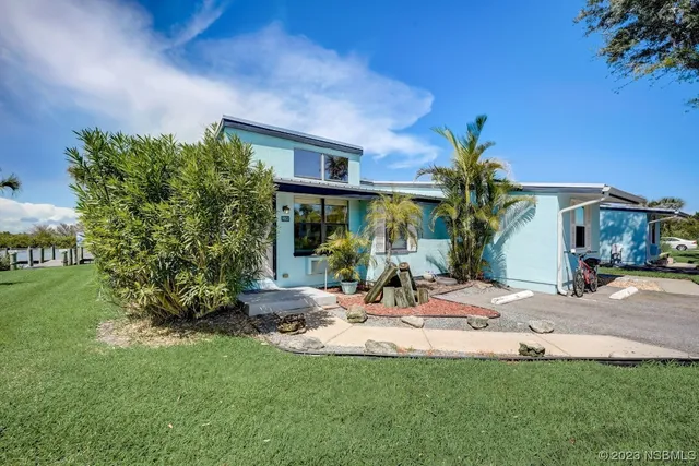 a view of a house with backyard and sitting area