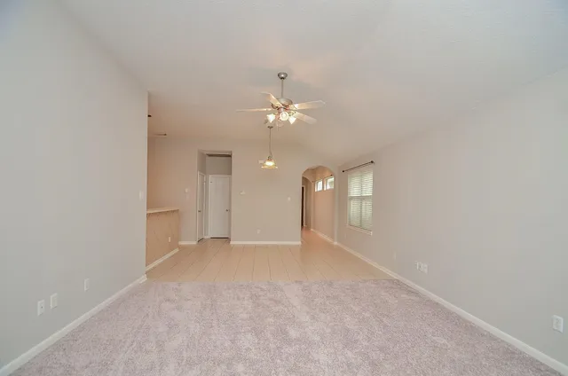 a view of an empty room with a ceiling fan