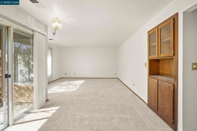 a view of a big room with windows and chandelier