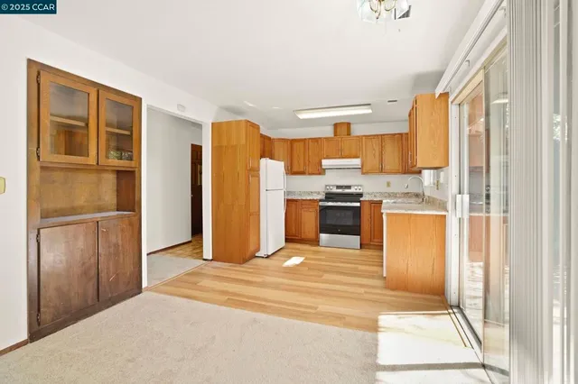 a view of a kitchen with wooden cabinet and stainless steel appliances